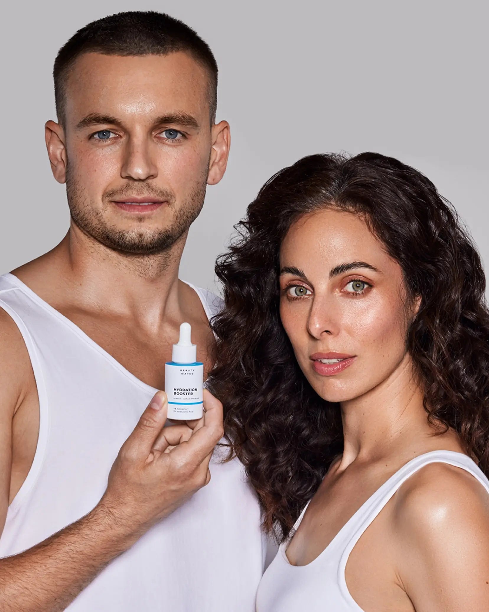 Ein Mann und eine Frau in weißen Tops halten den Beauty Mates Hydration Booster und präsentieren ihn